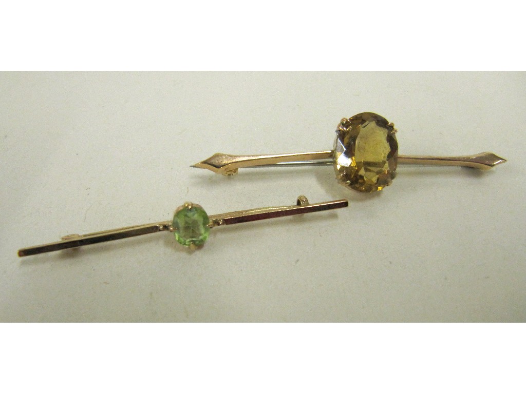 Appraisal: Two Edwardian gold bar brooches one with central peridot the