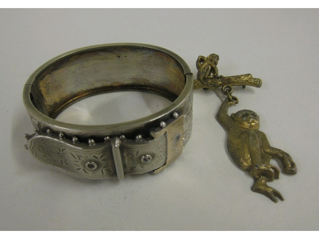 Appraisal: Lot comprising a Victorian silver bangle and a monkey brooch