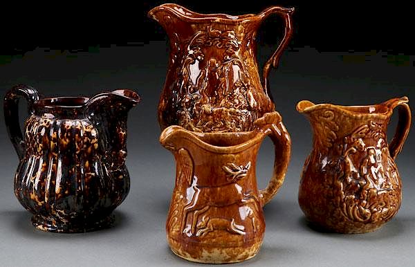 Appraisal: BENNINGTON GLAZED PITCHERS A GROUP OF FOUR BENNINGTON ROCKINGHAM BROWN