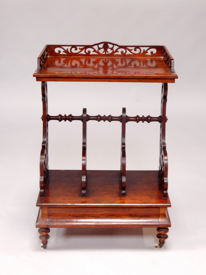 Appraisal: A Victorian walnut Canterbury whatnot the foliate fretwork galleried top