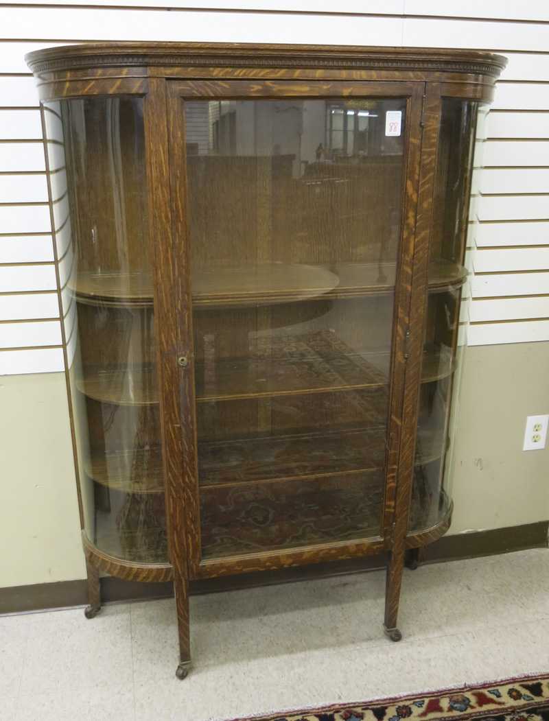 Appraisal: AN OAK AND CURVED GLASS CHINA CABINET American c the