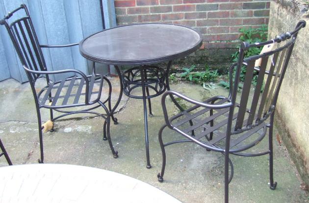 Appraisal: A black painted circular garden table raised on four downswept