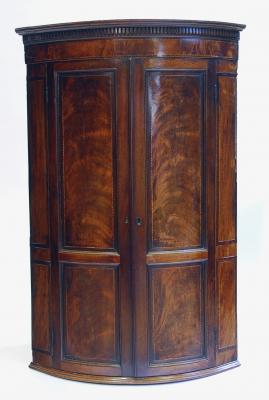 Appraisal: A GEORGE III MAHOGANY CORNER CUPBOARD of bowed form with