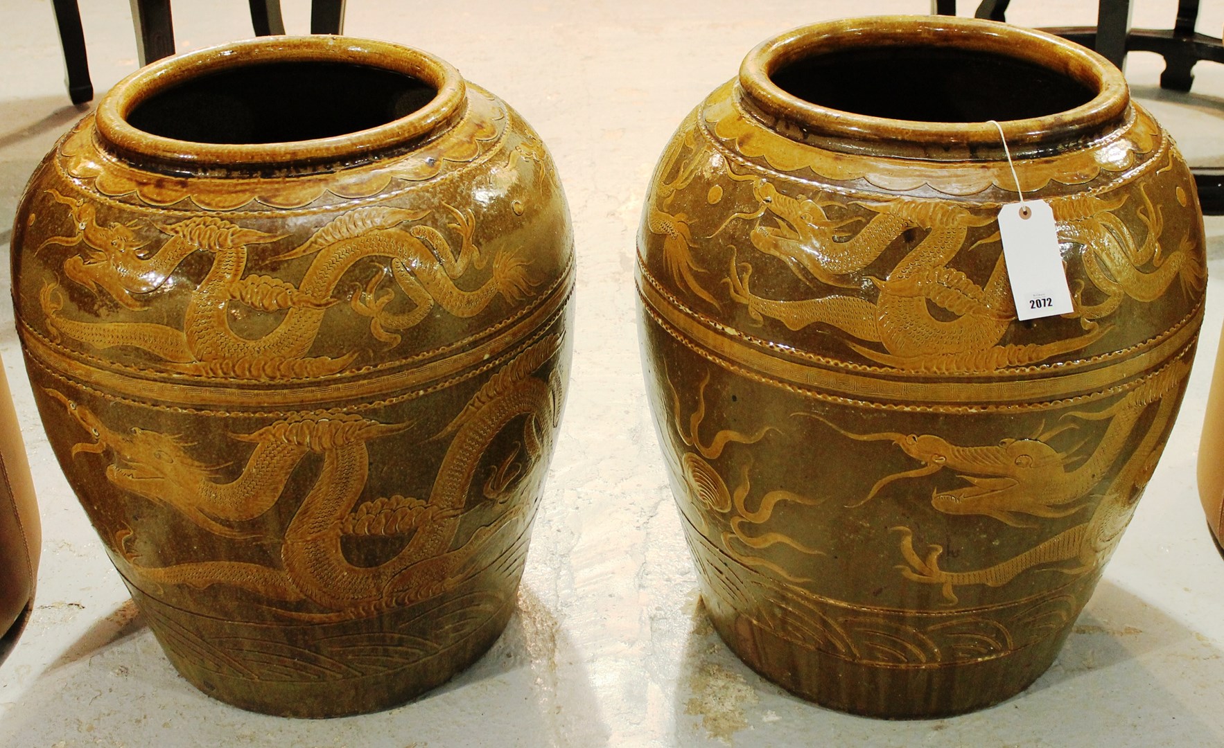 Appraisal: A large pair of terracotta jars slip decorated with dragons