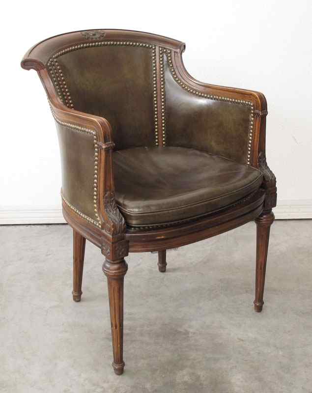 Appraisal: WALNUT BROWN LEATHER LIBRARY CHAIR Carved floral medallion in top