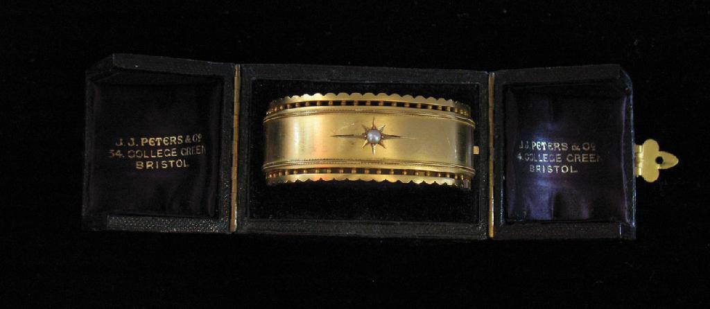 Appraisal: AN EDWARDIAN BANGLE the top with fancy frill edges and