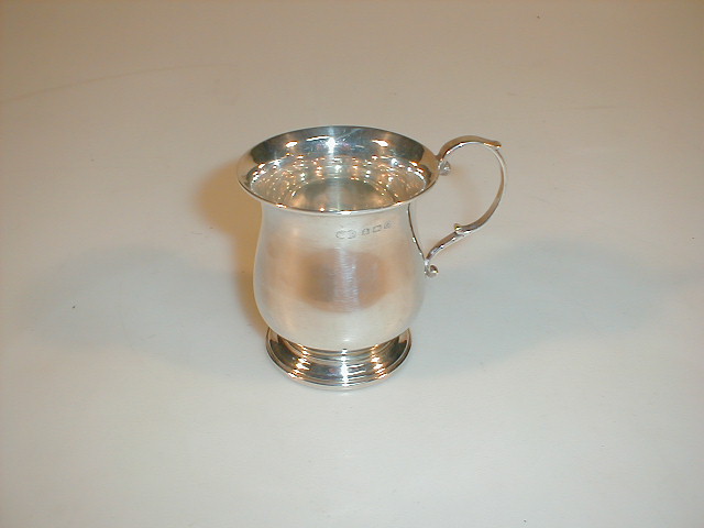 Appraisal: A silver baluster mug with a double scroll handle on