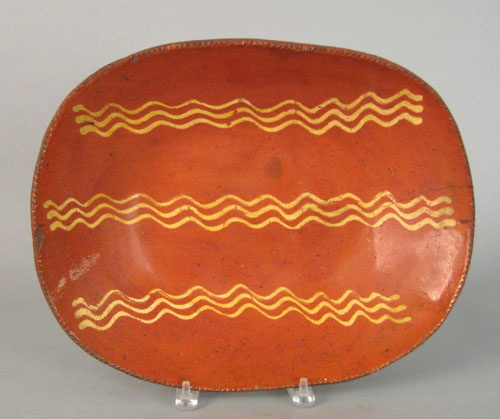 Appraisal: Pennsylvania redware loaf dish th c with yellow slip wavy