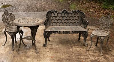 Appraisal: A cast iron suite of garden furniture comprising a settee