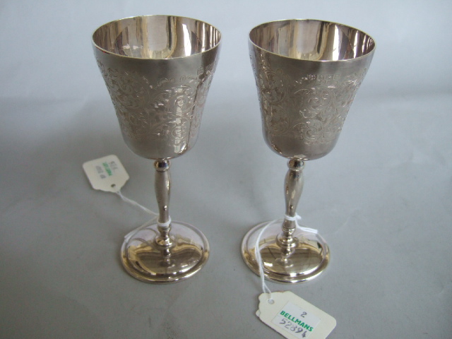 Appraisal: A pair of silver goblets with engraved decoration turned stems