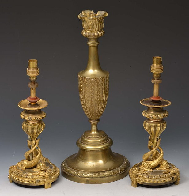 Appraisal: A PAIR OF GILT METAL DOLPHIN COLUMN CANDLESTICKS converted to