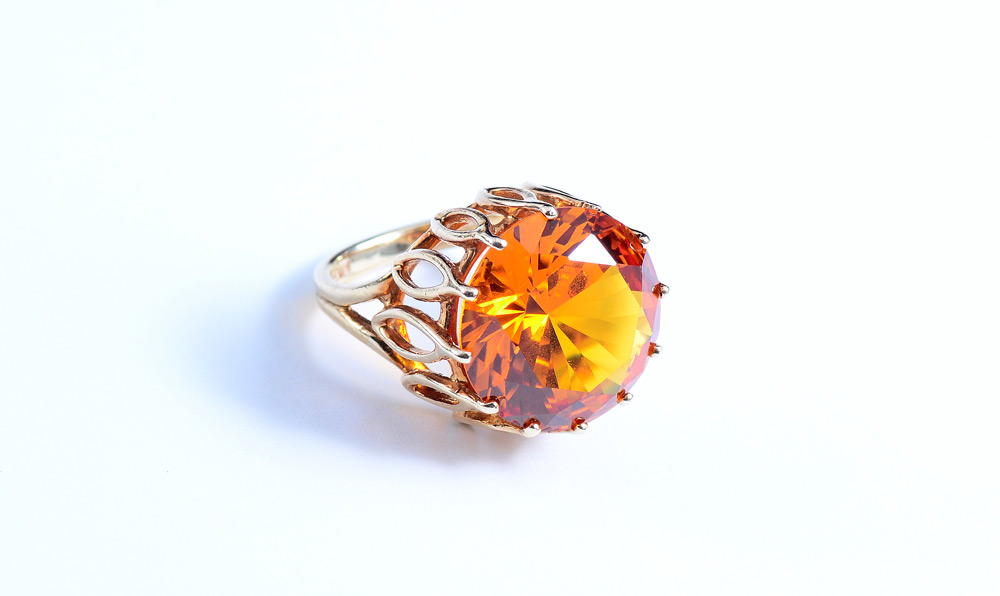 Appraisal: ORANGE SAPPHIRE RING High profile K yellow gold ring with