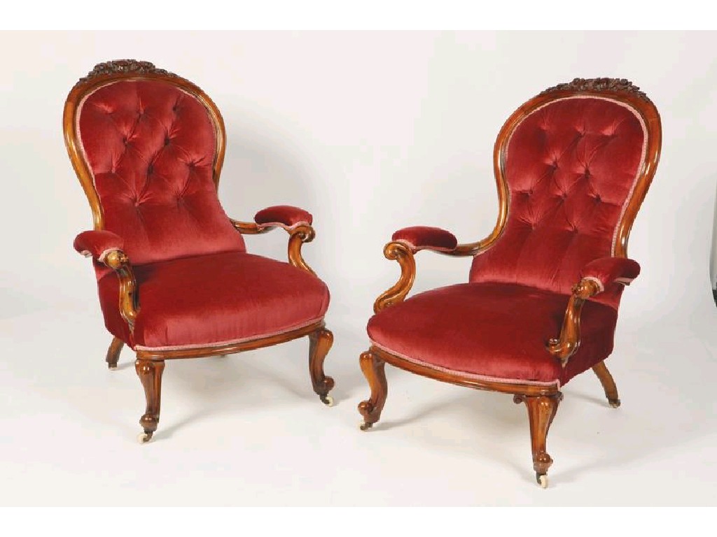 Appraisal: A PAIR OF VICTORIAN WALNUT ARMCHAIRS with buttoned spoon-shaped backs