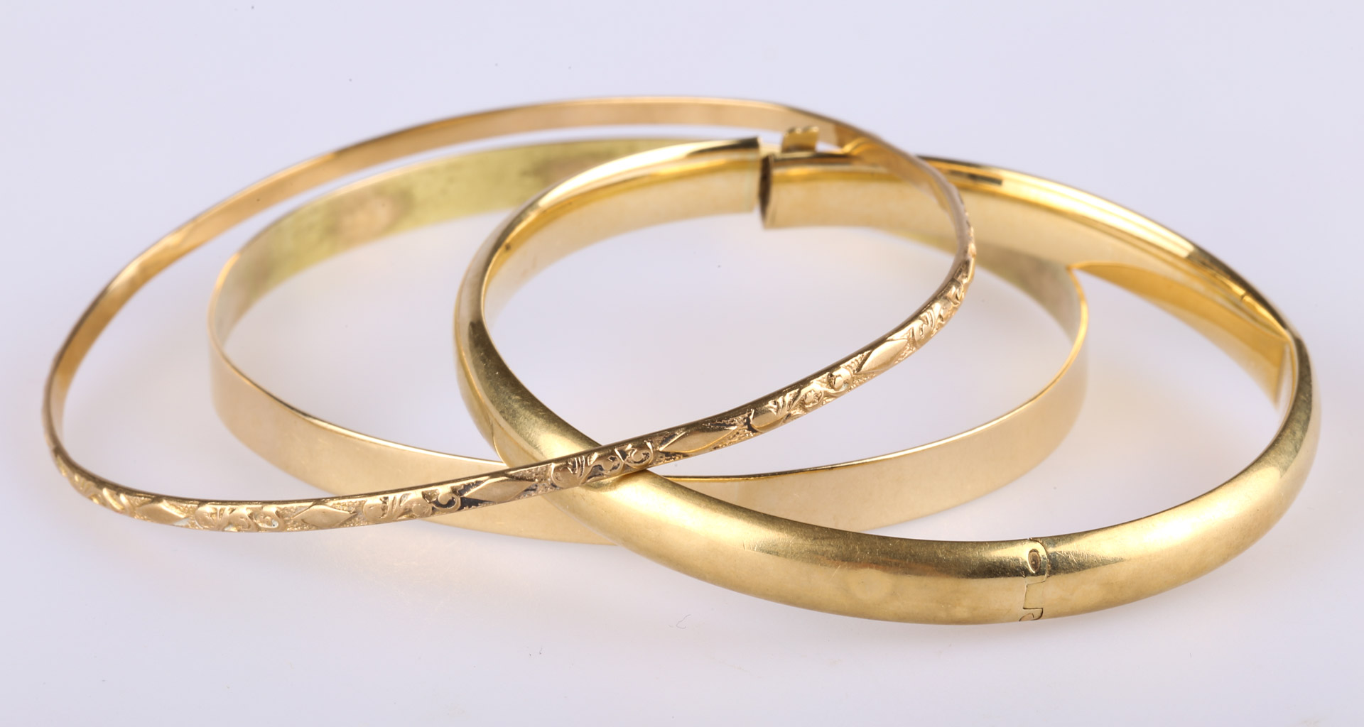 Appraisal: Three Gold Bangle Bracelets K smooth hinge opening x K