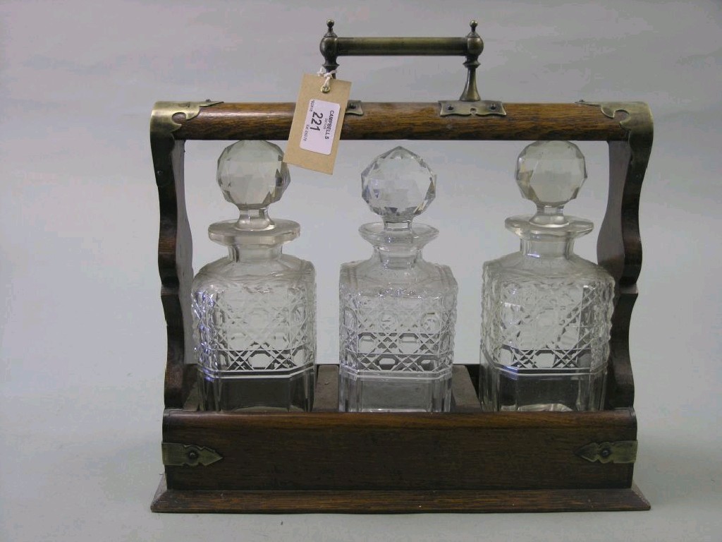 Appraisal: A Victorian oak tantalus with silver plated mounts containing three