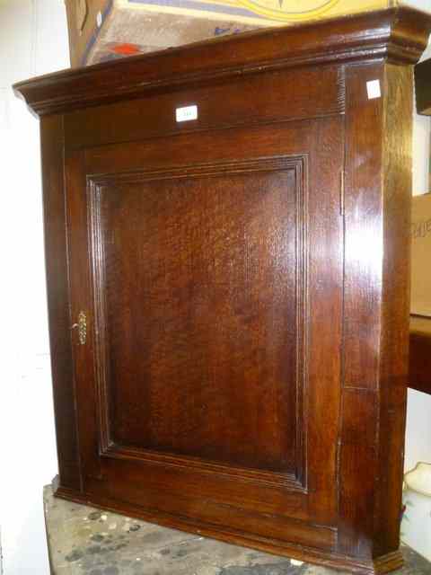 Appraisal: A GEORGIAN OAK CORNER CUPBOARD of simple form enclosed by