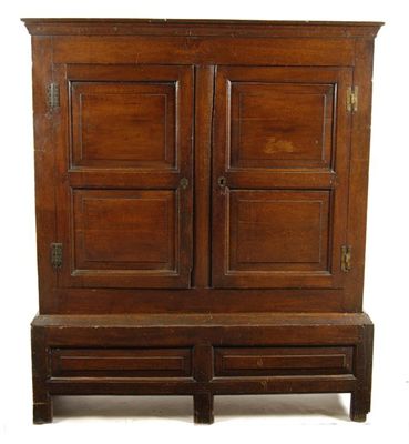 Appraisal: An oak press cupboard the moulded cornice above a pair