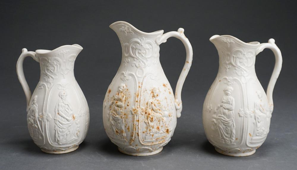 Appraisal: THREE GRADUATED STAFFORDSHIRE WHITE GLAZED STONEWARE PITCHERS MOLDED WITH PANELS