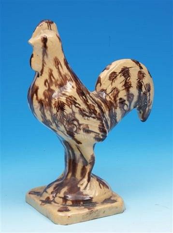 Appraisal: A th Century pottery honey and brown glazed pottery cockerel