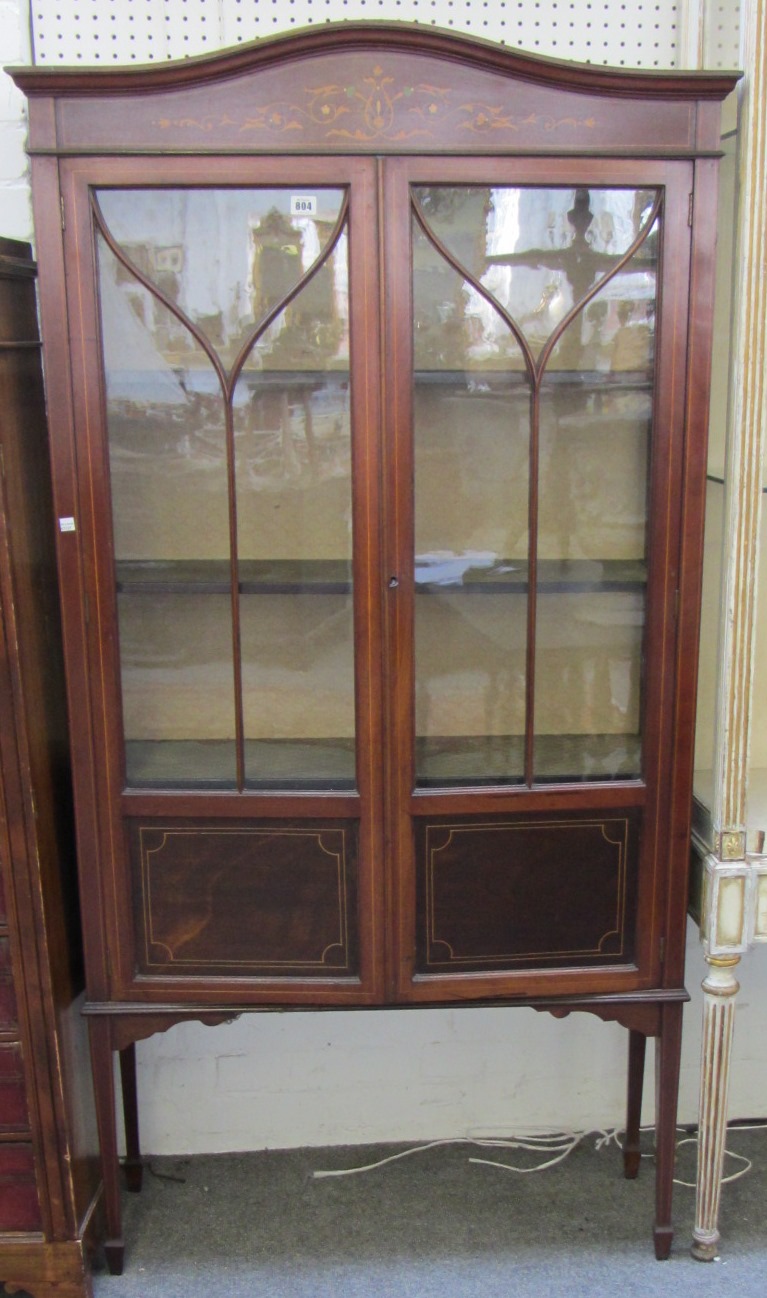 Appraisal: An Edwardan marquetry inlaid mahogany two door display cabinet on