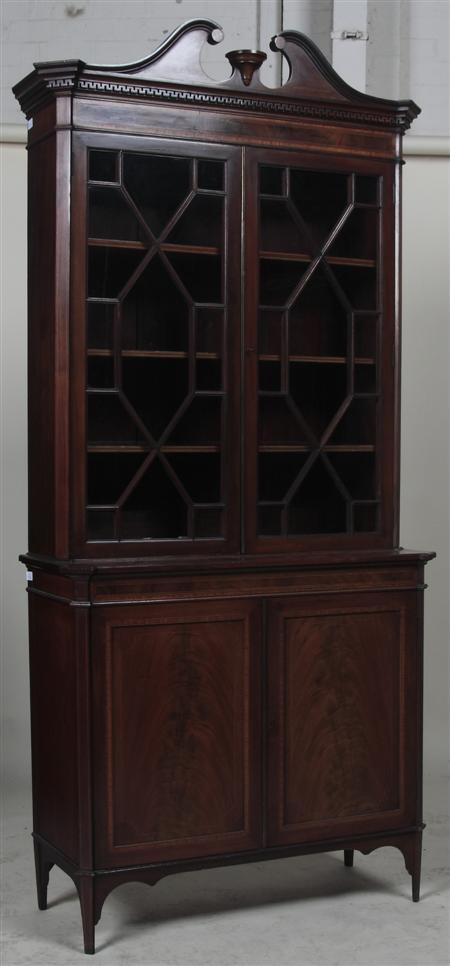 Appraisal: An Edwardian mahogany inlaid bookcase the swan-neck pediment over Greek