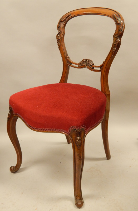 Appraisal: A Victorian walnut balloon back chair with a carved back