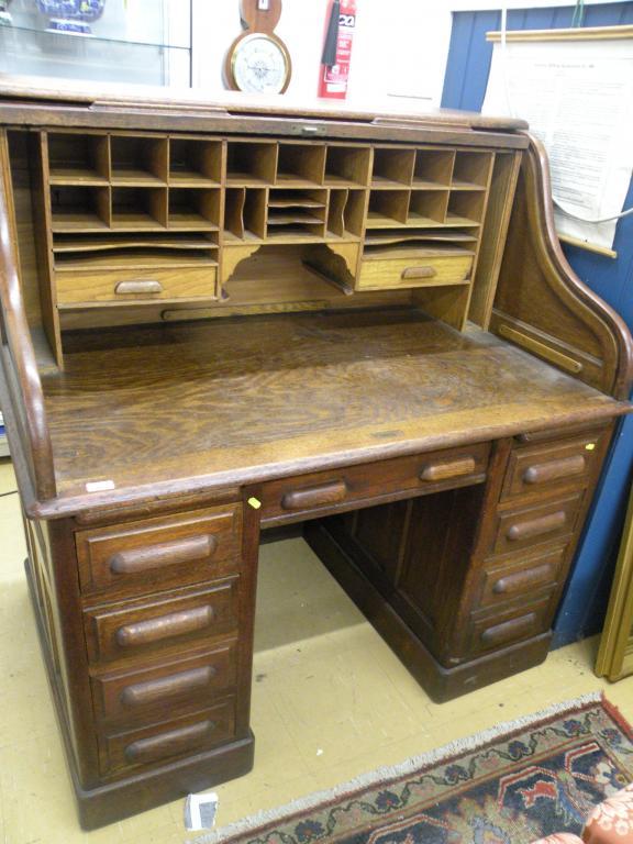 Appraisal: An oak roll top desk with an arrangement of nine