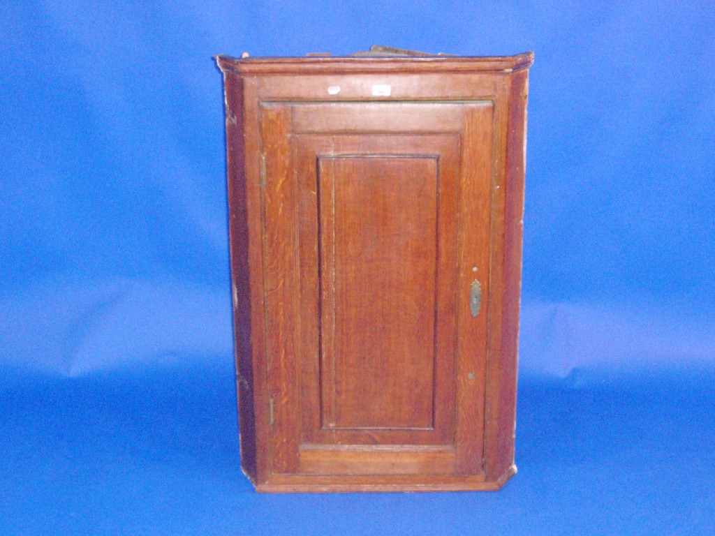 Appraisal: A George III oak hanging corner cupboard with single door