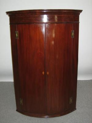 Appraisal: A MAHOGANY CORNER CUPBOARD early th century of quadrant form