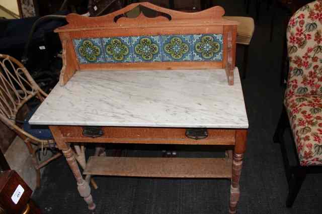 Appraisal: A VICTORIAN WASHSTAND with raised tiled back on a marble