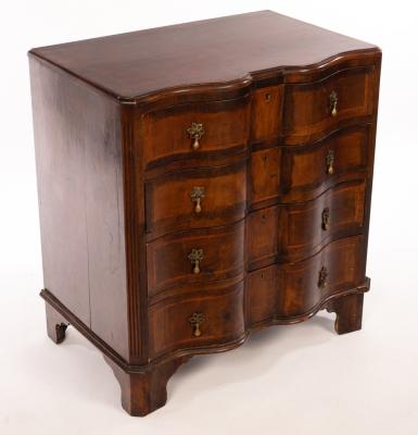 Appraisal: A reproduction chest of four long drawers with a serpentine