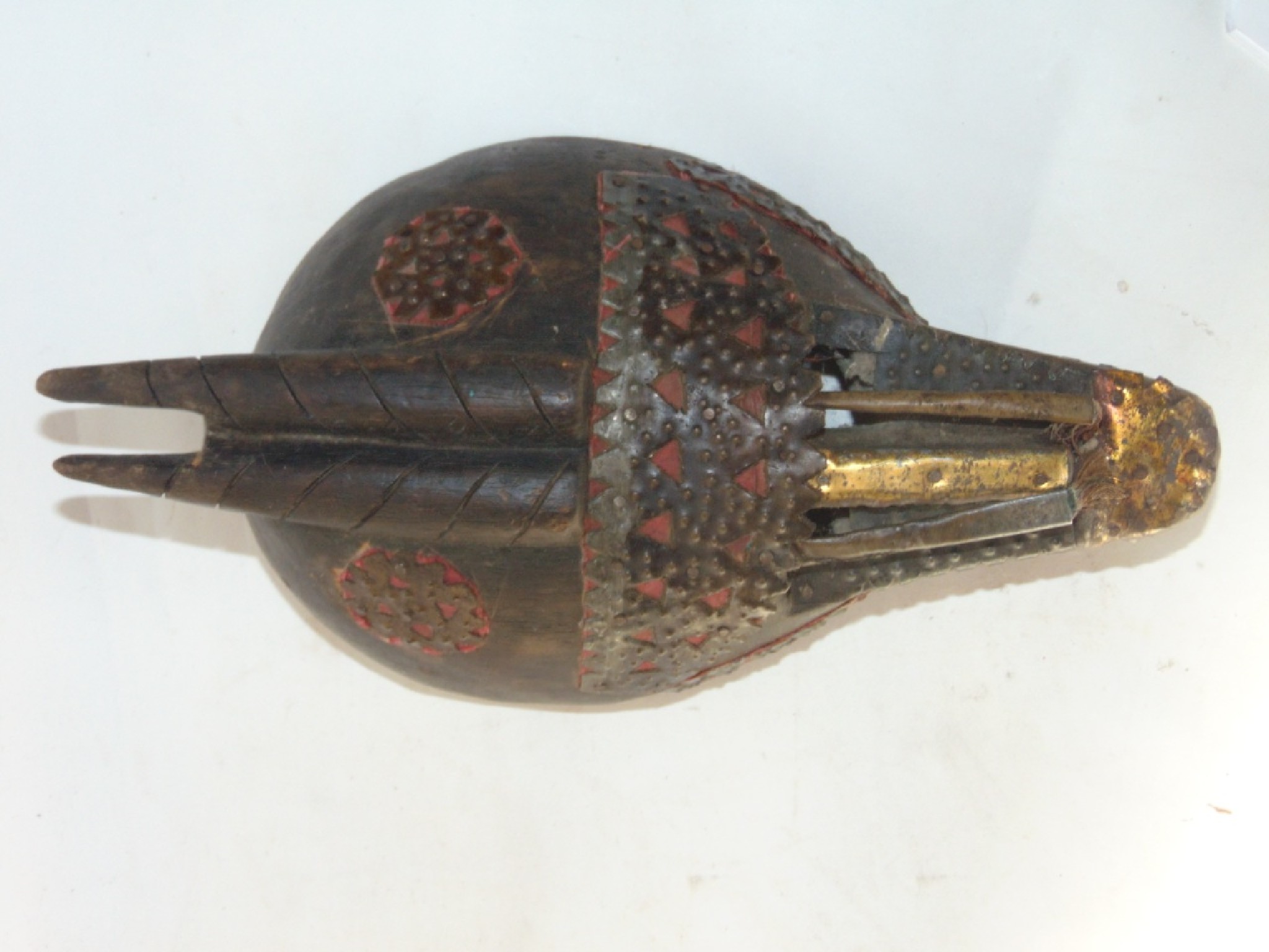 Appraisal: An unusual African carved timber mask with applied metallic and