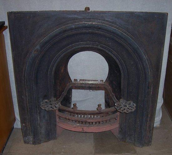 Appraisal: A cast iron fireplace with fluted arch surmount cm x