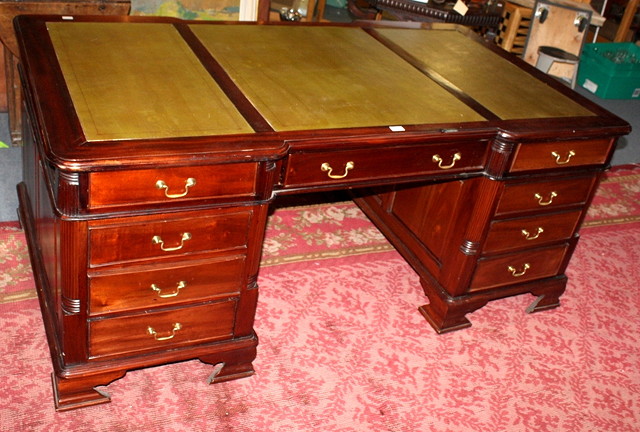 Appraisal: A MAHOGANY PARTNERS DESK with shaped top inset green tooled