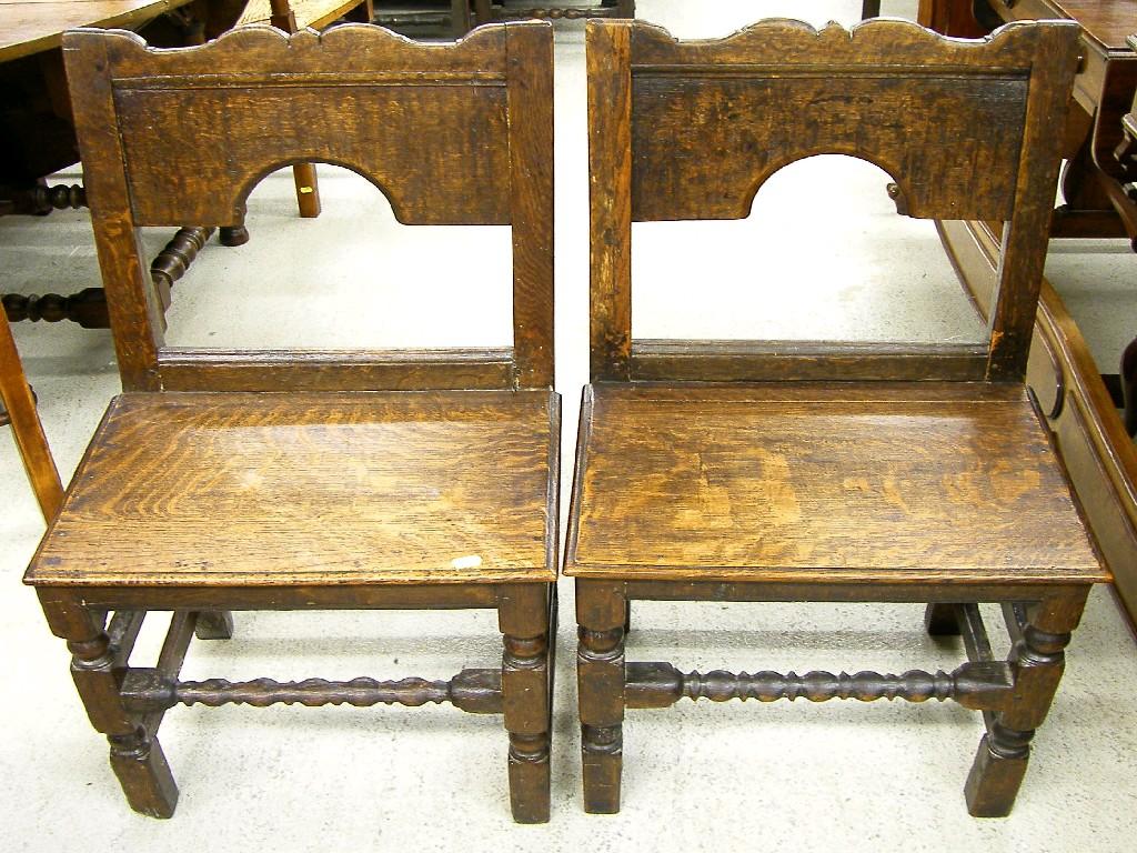 Appraisal: Pair of antique oak hall chairs the open arched shaped