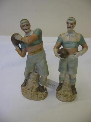 Appraisal: A PAIR OF EDWARDIAN BISQUE FIGURES modelled as rugby players