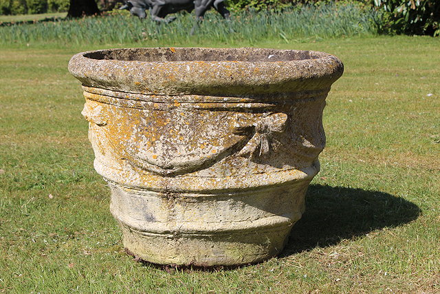 Appraisal: A RECONSTITUTED STONE CAST CIRCULAR TAPERING GARDEN PLANTER with ribbon