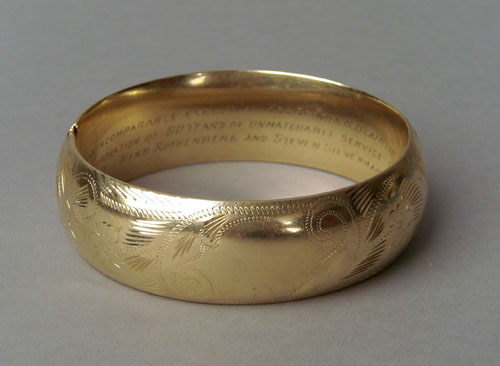 Appraisal: K yellow gold bangle with inscription and engraved vine decoration