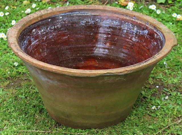 Appraisal: A TERRACOTTA CROCK of conical form and with glazed interior