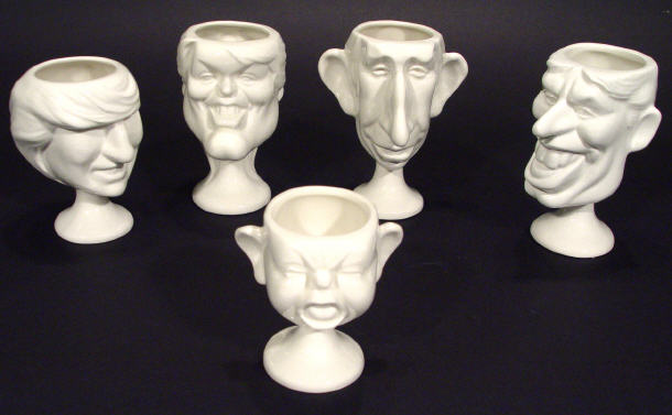 Appraisal: Set of five white glazed pottery Spitting Image egg cups