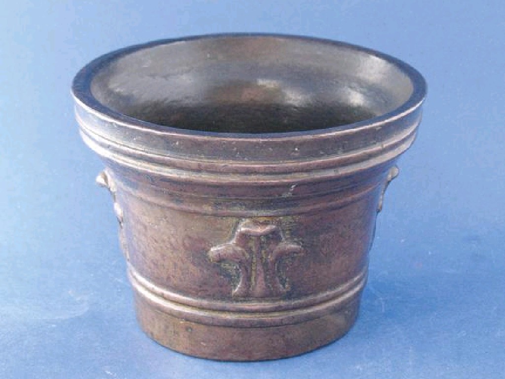 Appraisal: A BRONZE MORTAR with ringed exterior decorated with four fleur