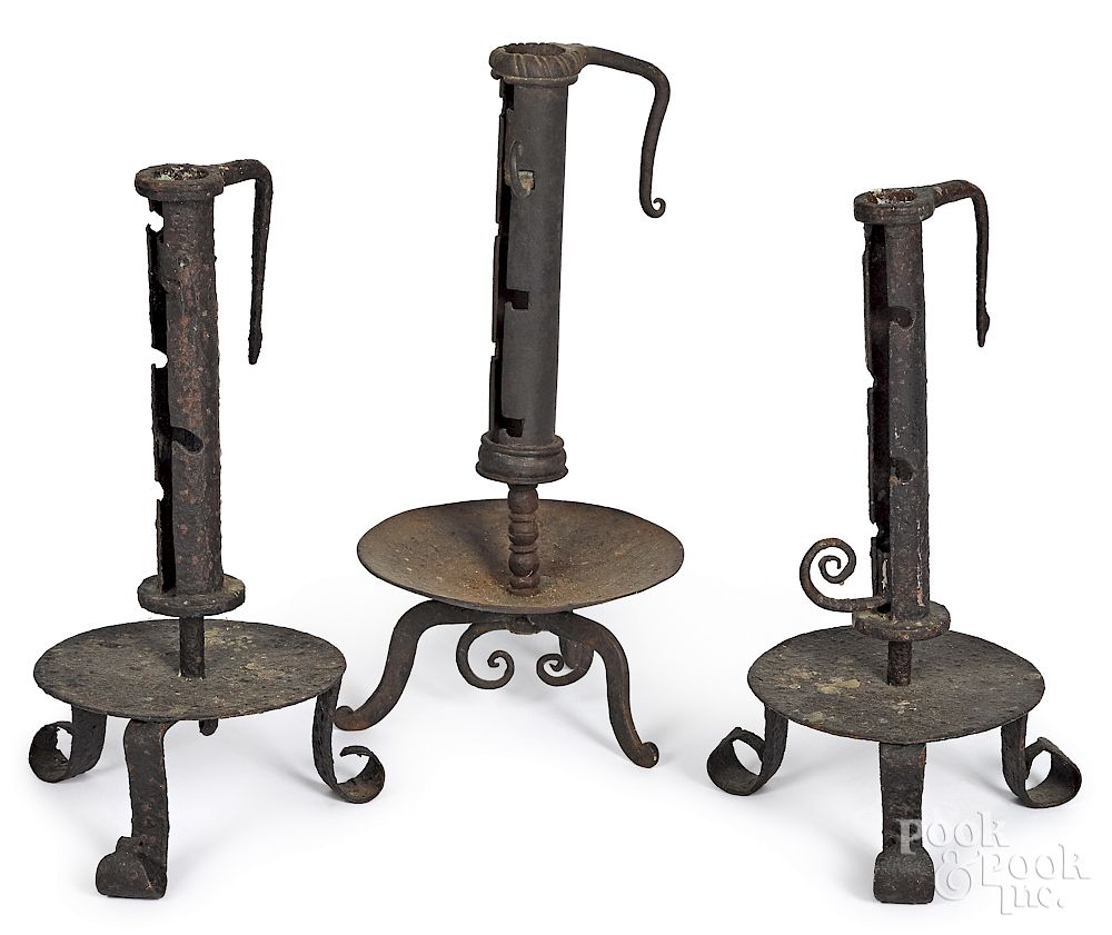 Appraisal: Three wrought iron adjustable candlesticks Three wrought iron adjustable candlesticks