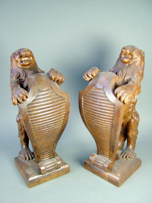 Appraisal: A pair of carved oak heraldic lions supporting shields on