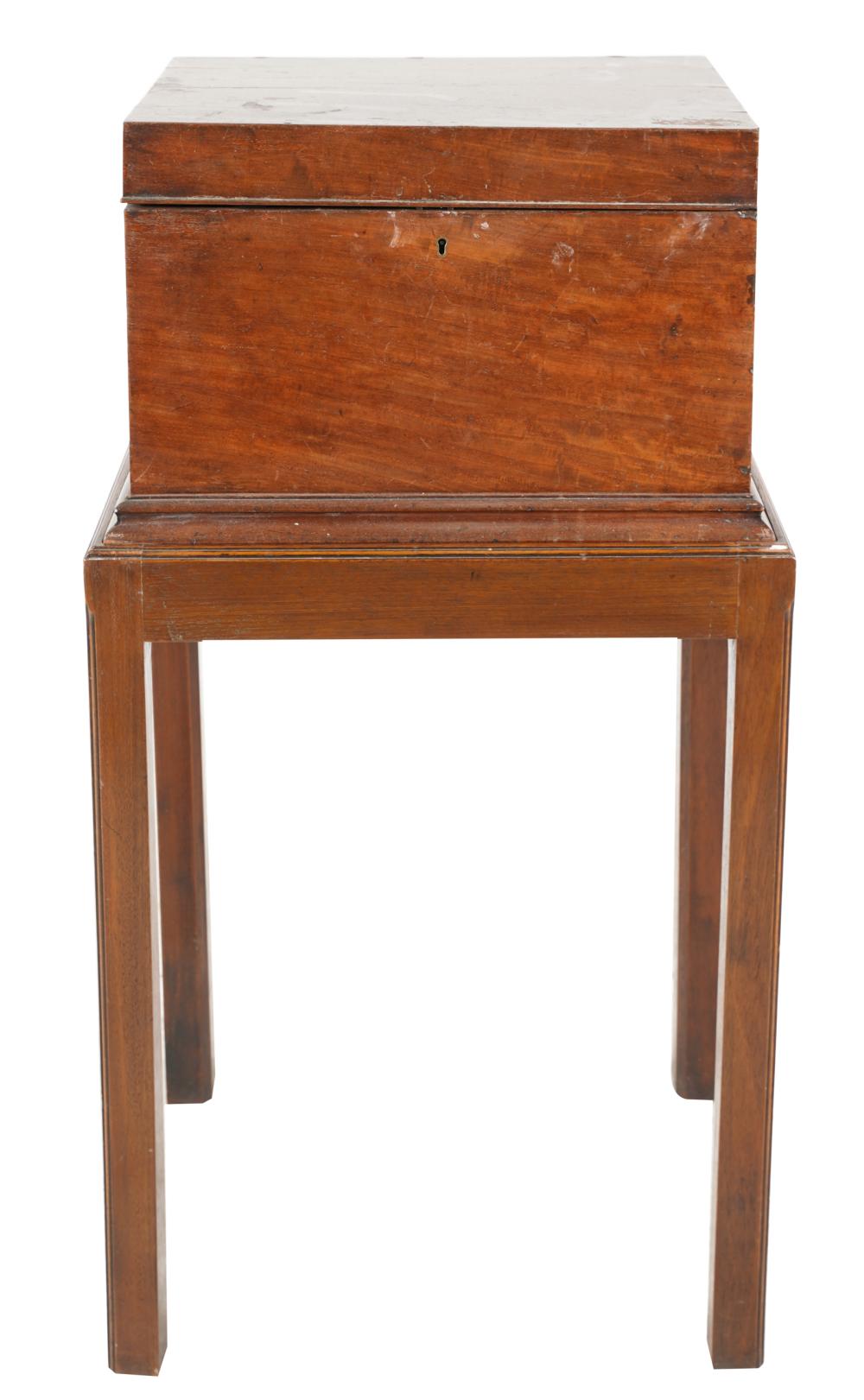 Appraisal: MAHOGANY TANTALUS ON STAND th century the hinged lid opening