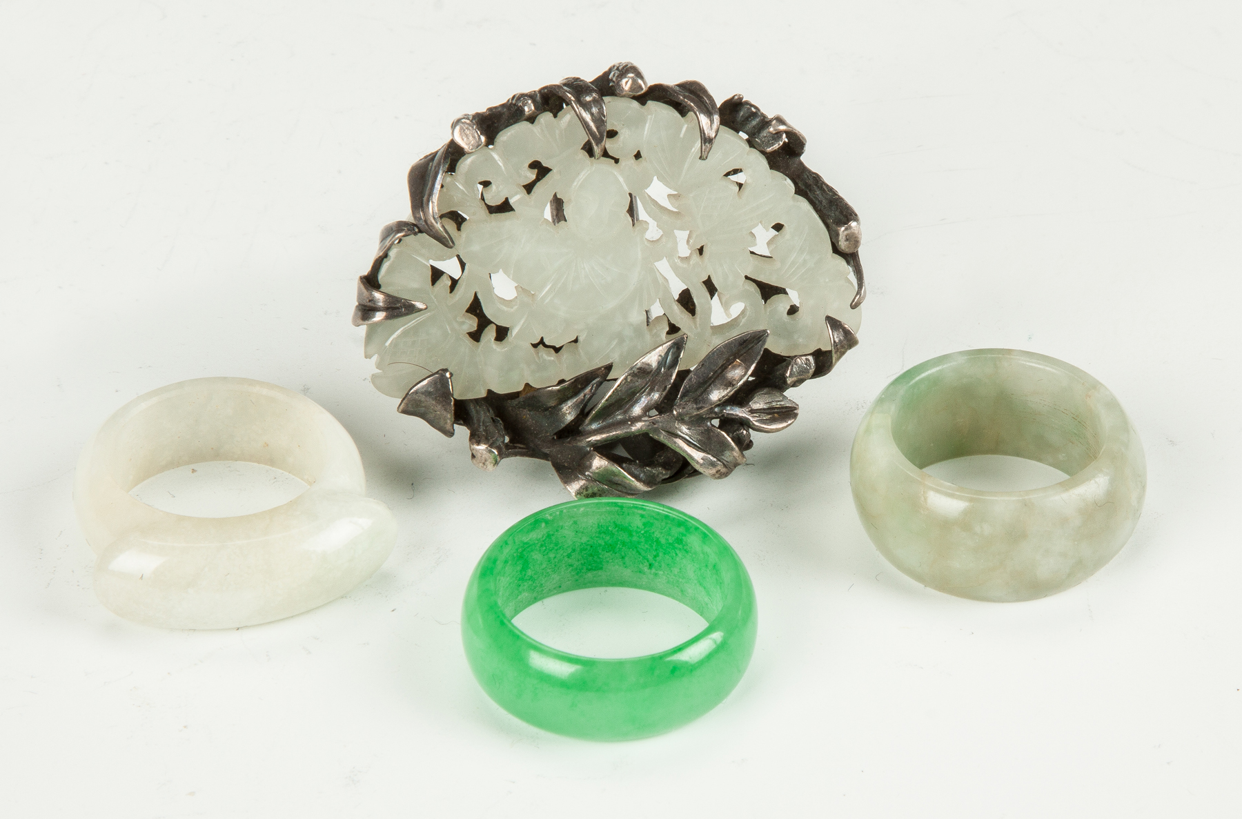 Appraisal: Four Chinese Jade Rings One is pierce carved silver mounted