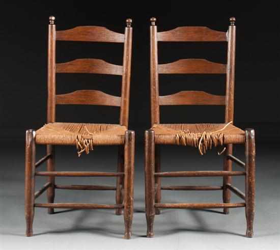 Appraisal: Pair of American vernacular oak rush seat ladder-back side chairs