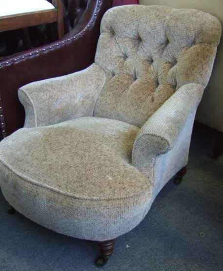 Appraisal: An Edwardian deep seated button back armchair with outswept arms