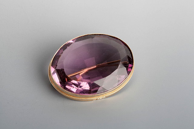 Appraisal: AN AMETHYST BROOCH oval faceted stone set in a plain