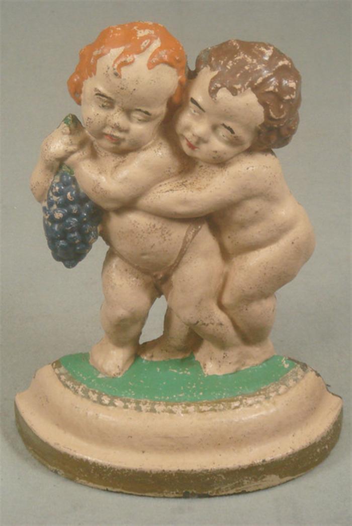 Appraisal: Cast iron doorstop large hollow back nude children sharing grapes