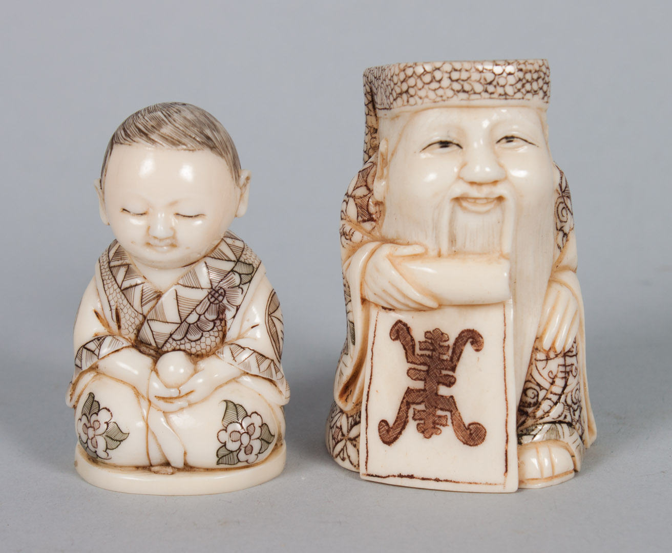 Appraisal: Two Japanese carved bone netsukes carved and ink highlighted figures